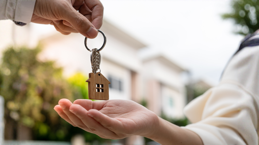 Mano de persona entregando llaves de vivienda de protección oficial